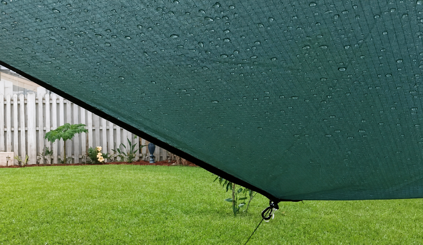 View from beneath a rain-beaded hammock tarp during a backyard rain test
